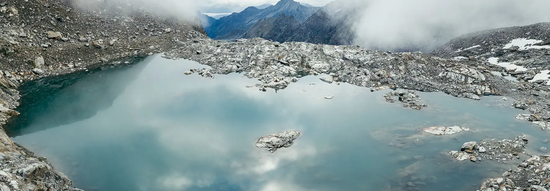 Bergsee mit Wolken und Felsen
